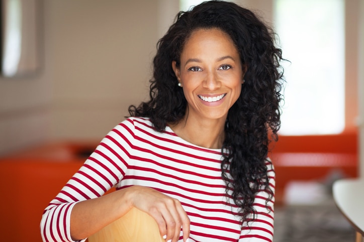 African American Woman Sitting On a Chair. She is relaxing at home